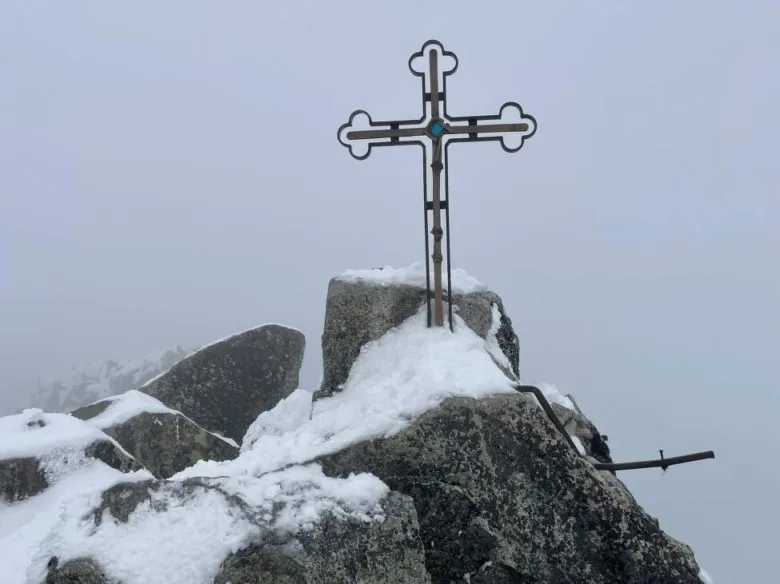 Kříž na vrcholu nejvyšší hory Slovenska pokrytý sněhem.