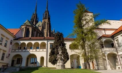 Dvořák kostela svatého Petra v Brně s arkádami sochou zeleným trávníkem