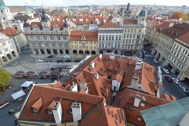 Pohled na střechy historického centra Prahy s kostelem.