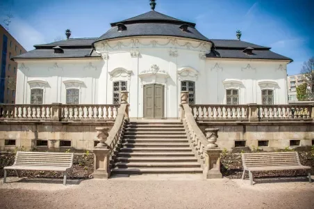 Historická budova v Brně s schodištěm vedoucím k hlavnímu vchodu.