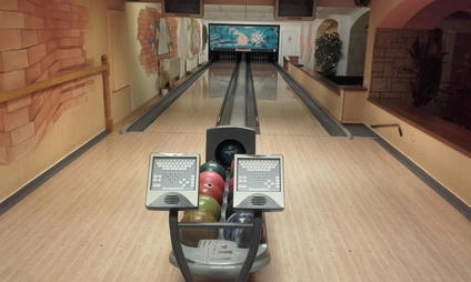 Vnitřek bowlinghaly s dráhou a návratkou koulí.