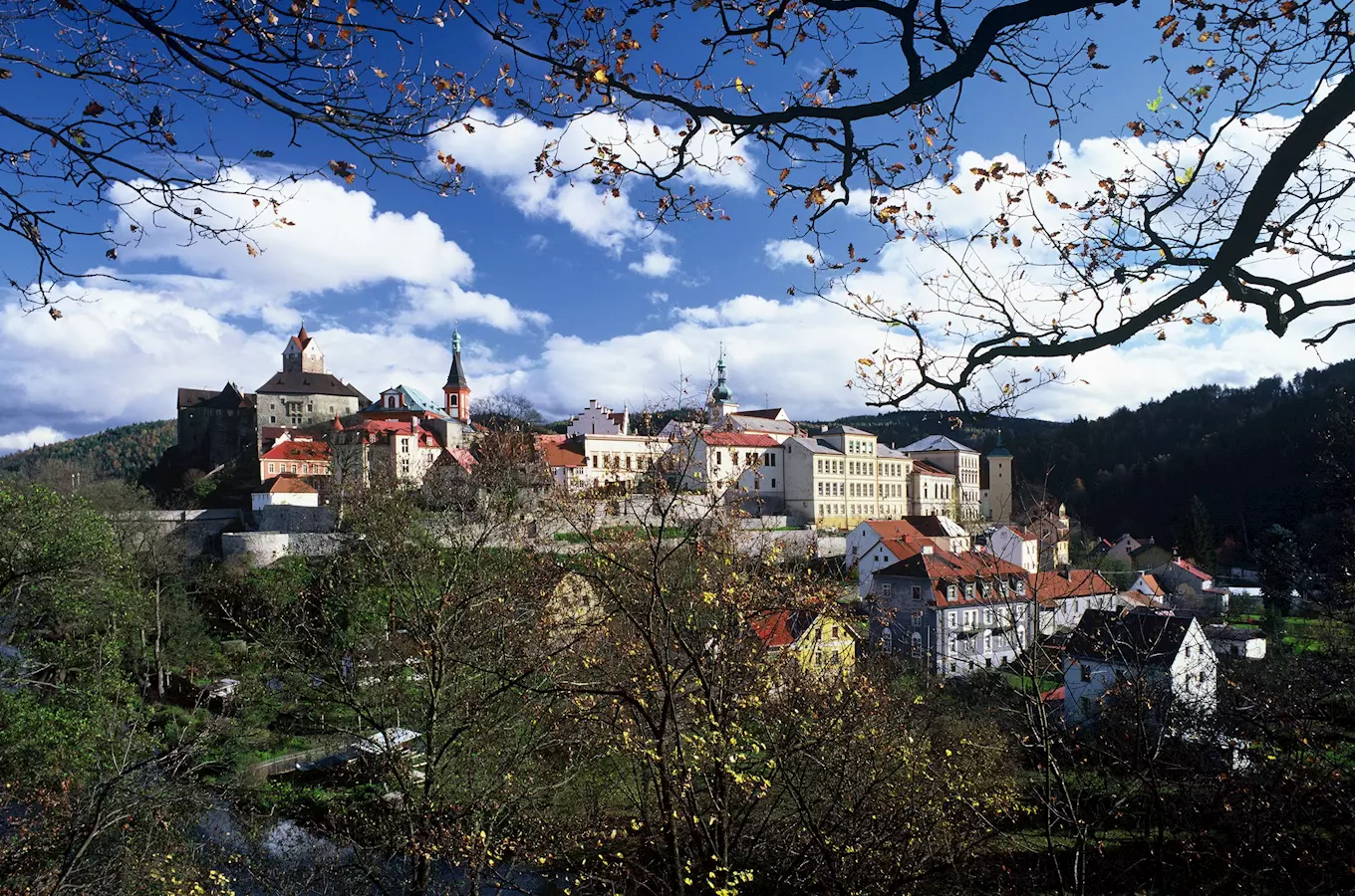 Pohled na hrad Loket s městem pod ním za slunečného dne.