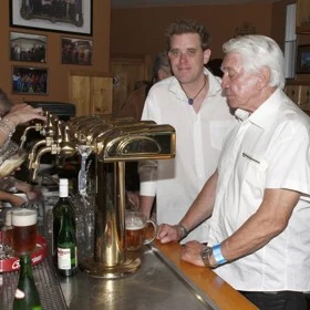 Dva muži v bistro u piva za barem s kohouty na pivu.