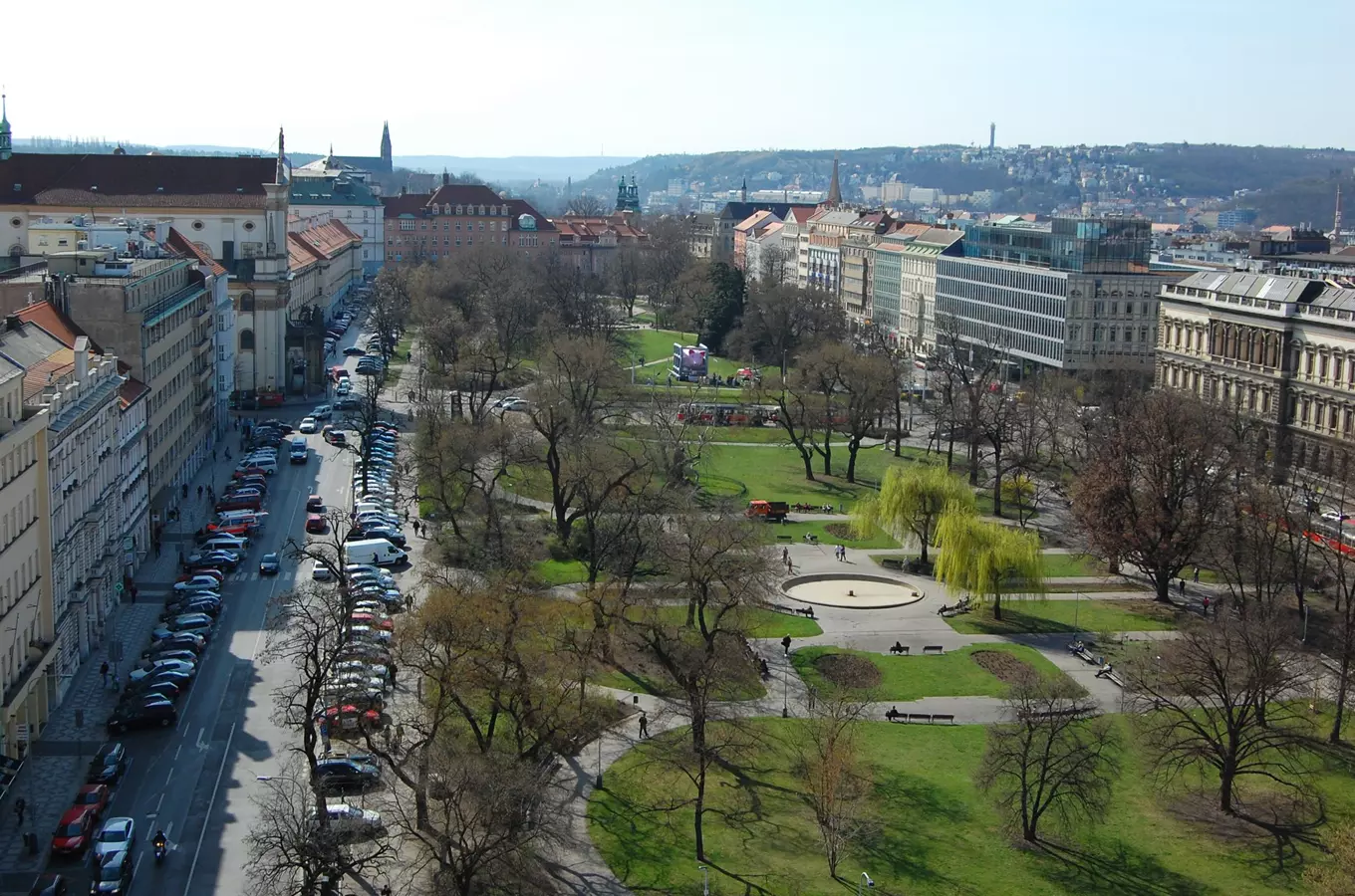 Pohled na Karlův náměstí v Praze s parkem a ulicemi.
