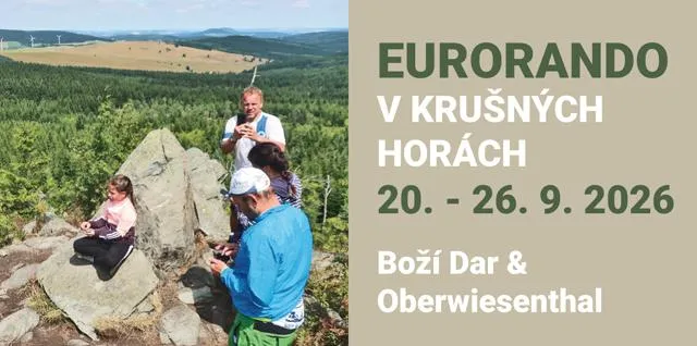 Skupina turistů na skalnatém vrchu v Krusných horách.